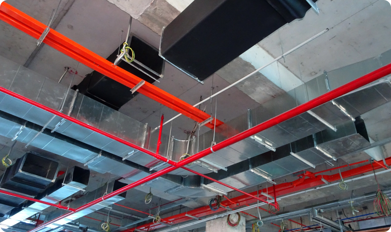 Red pipes in the ceiling of an industrial building supplies an automatic fire sprinkler system